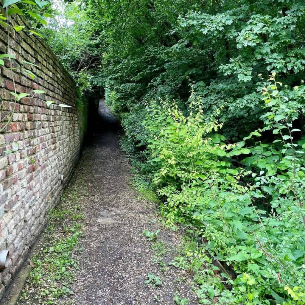 Smal wandelpad langs een stenen muur