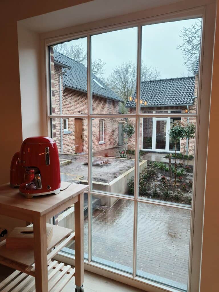 Uitzicht op de binnenkoer vanuit de keuken van de vakantiewoning bij Hof van Sassenbroek in Tongeren-Borgloon, Haspengouw.