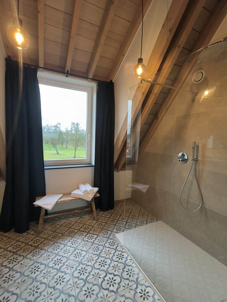 Regendouche in de badkamer van het brouwhuis van de vakantiewoning bij Hof van Sassenbroek in Tongeren‑Borgloon, Haspengouw.
