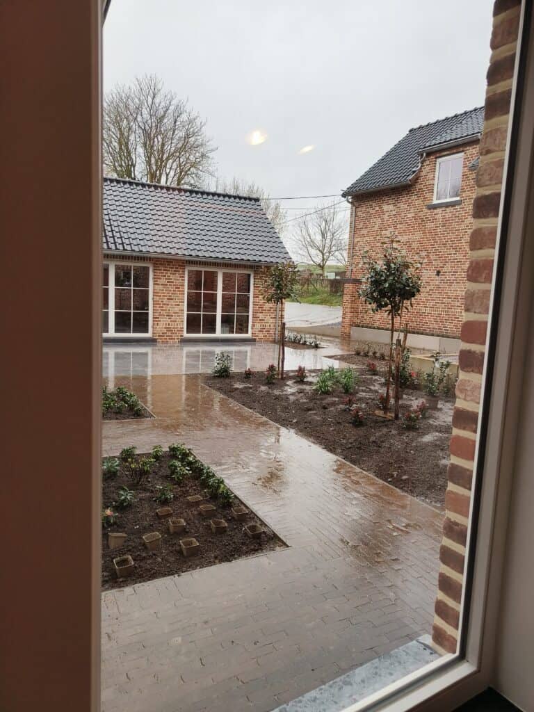 Uitzicht op de binnenkoer vanuit de zitruimte van het brouwhuis van de vakantiewoning bij Hof van Sassenbroek in Tongeren-Borgloon, Haspengouw.